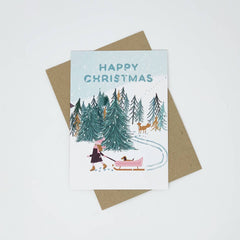 Happy Christmas girl with dog in pink sledge card