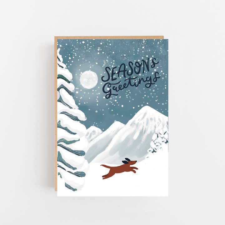 Season's greetings dog in snowy mountains card