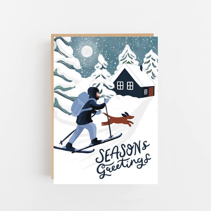 Season's greetings skier, dog and winter cabin card