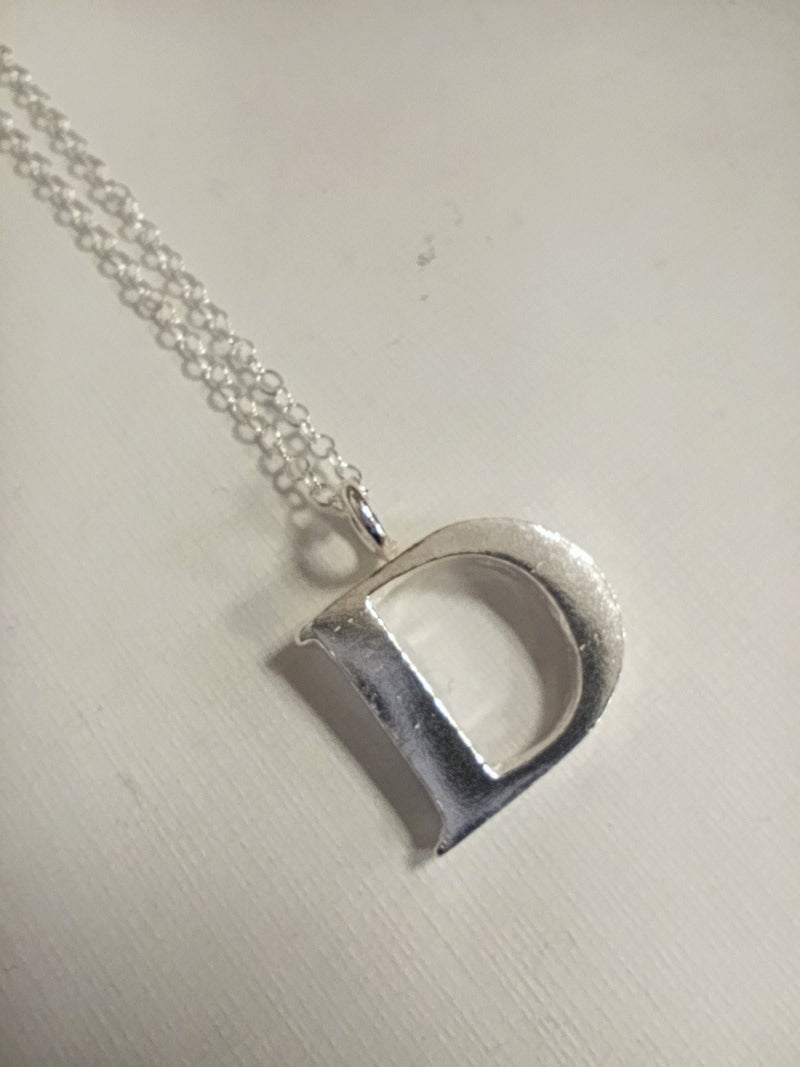 Sterling silver sand cast letter D necklace